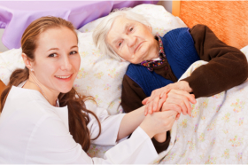 Caregiver accompanying a senior in bed